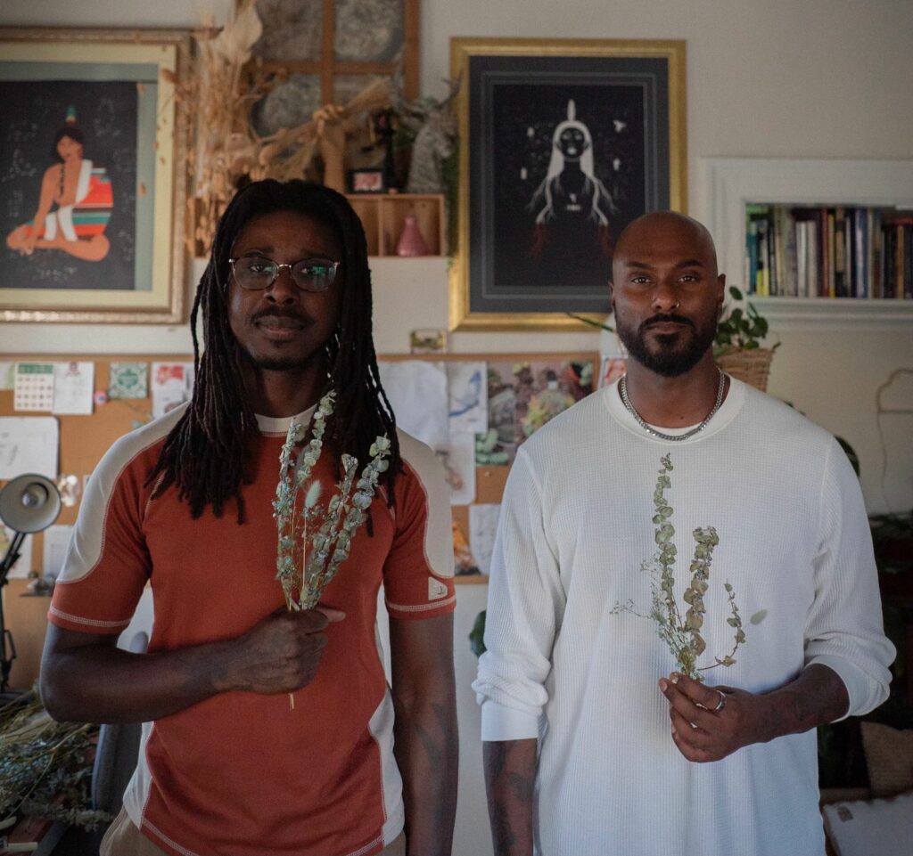 Manoj Dias and Nelson ZêPequéno holding plants